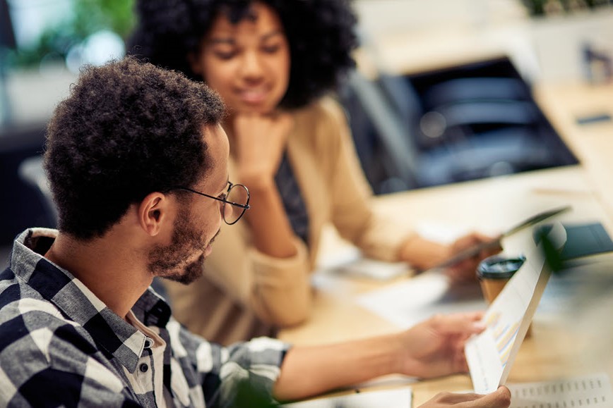 Two people reading a report.