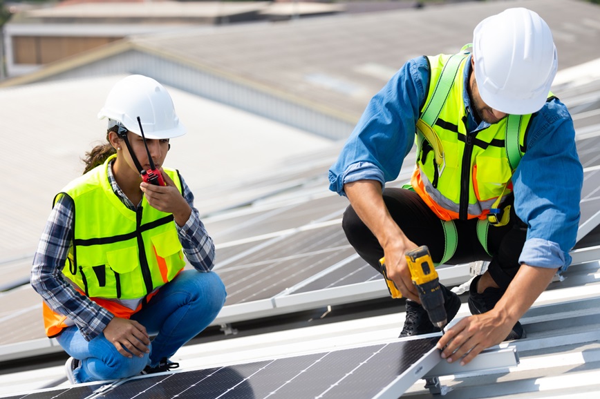 Teenager and adult working on solar panels Teenager and adult working on solar panels