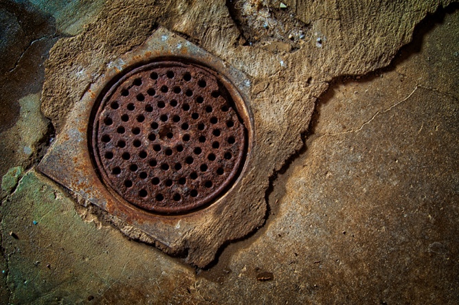 round, brown drain on cement floor