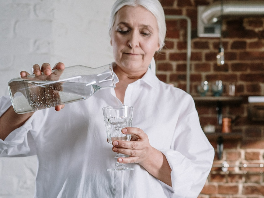 Person pouring glass of water Person pouring glass of water