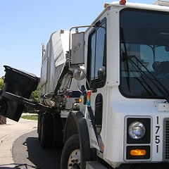 Garbage truck picking up can