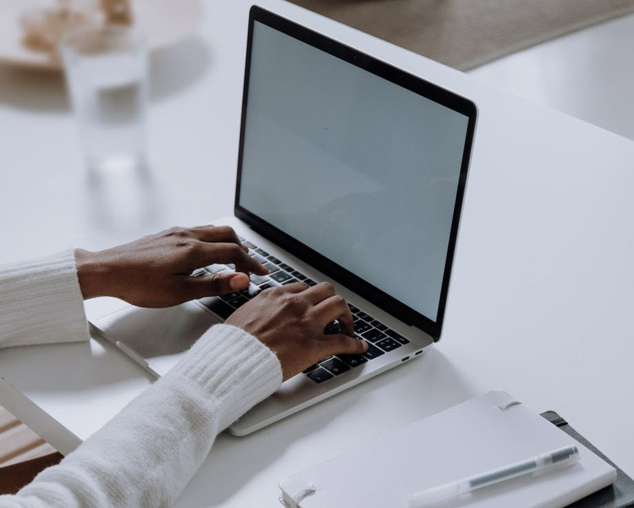 Hands typing at laptop