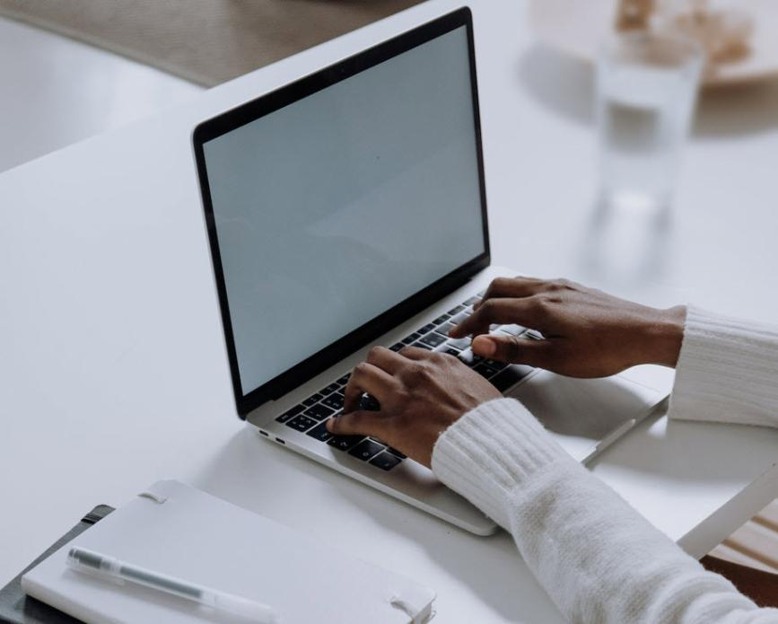Hands typing at laptop