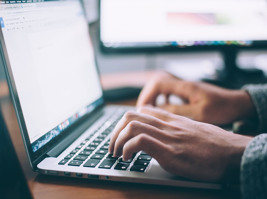 Hands typing on laptop