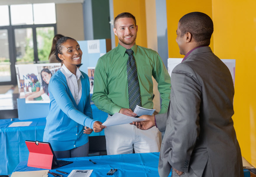 Three people talking at a job fair
