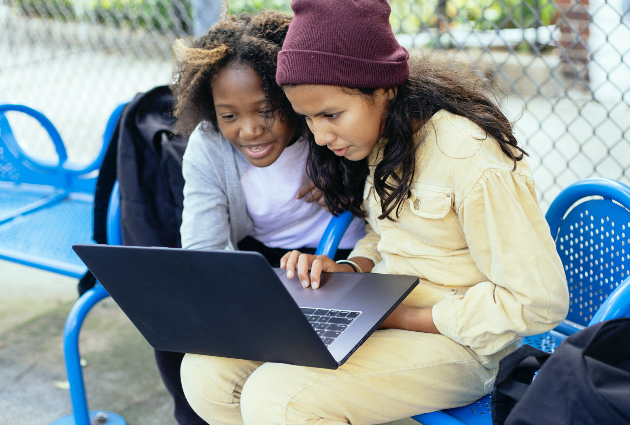 Children using laptop outdoors