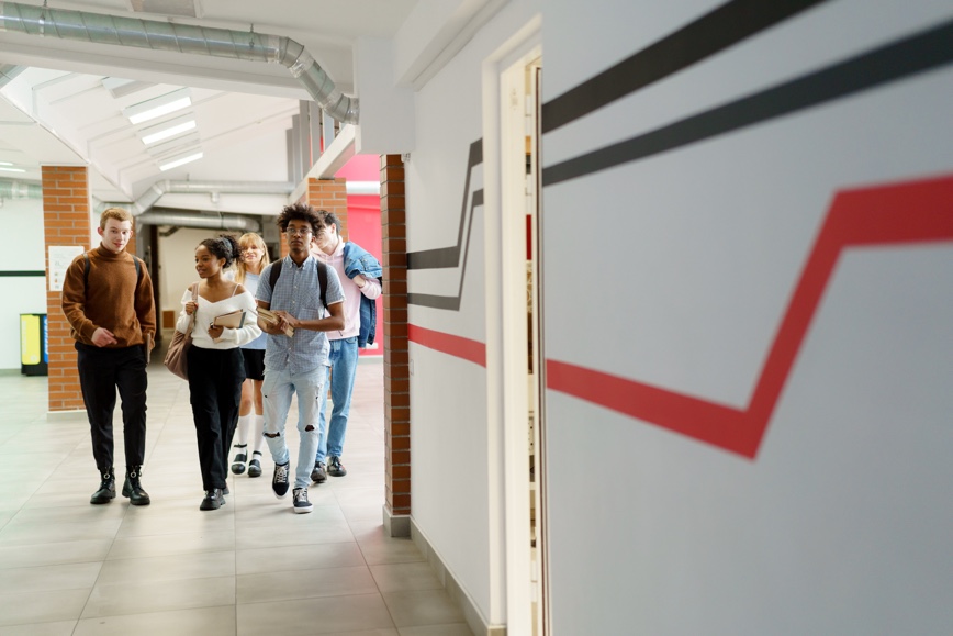 Group of student walking toward us in a hallway