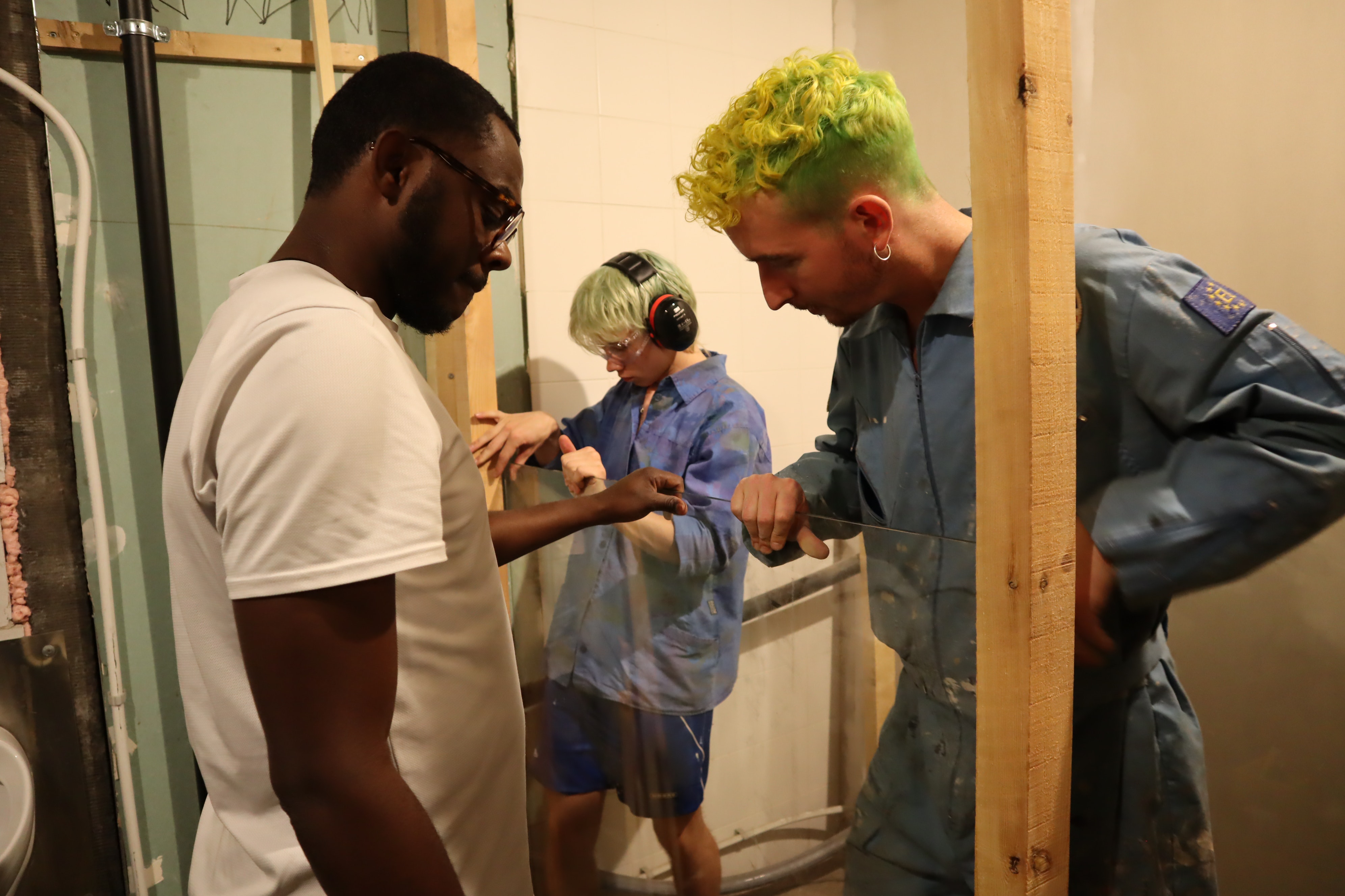 Three people doing interior carpentry work.
