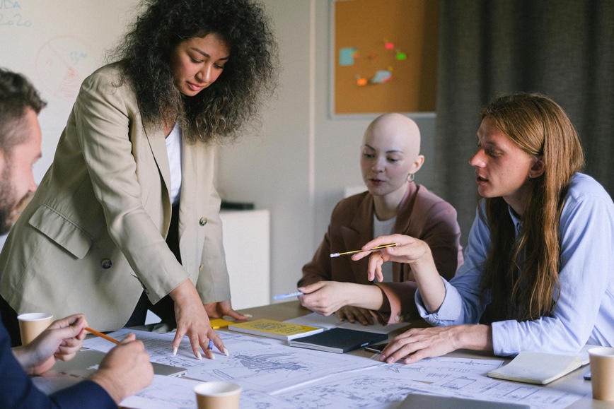 Diverse team reviewing blueprints Diverse team reviewing blueprints