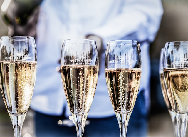 person serving Champagne in glasses