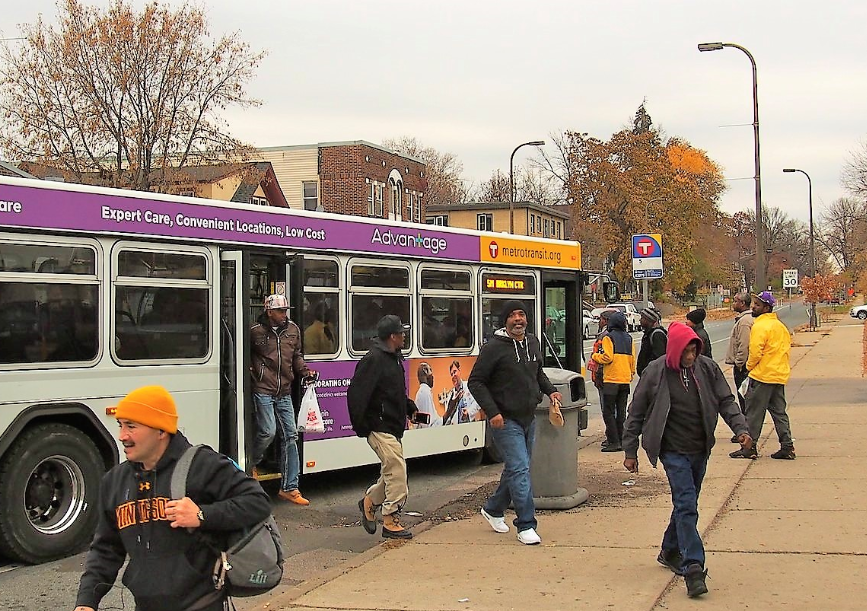 People unloading off a bus and walking away to their destinations